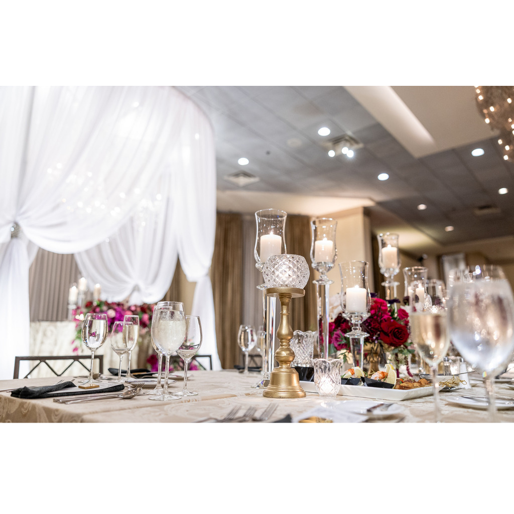 Wedding table with centerpieces and China. Bride and groom table is present in the background.